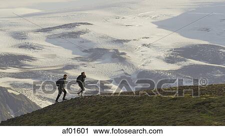 High angle view of hikers walking on grassy hilltop over snowy remote landscape View Large Photo Image Stock Image - High angle view of hikers walking on grassy hilltop over snowy remote landscape. Fotosearch