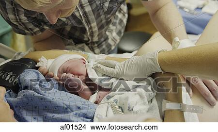 High angle view of new mother and father admiring newborn baby in hospital View Large Photo Image Picture - High angle view of new mother and father admiring newborn baby in hospital. Fotosearch