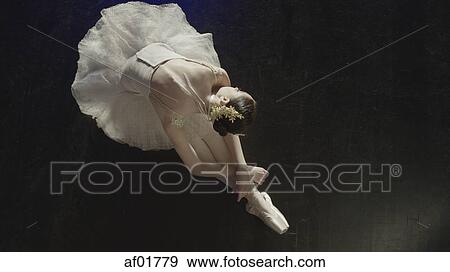 High angle view of performing dancer ballerina in tutu and toe shoes laying gracefully on stage floor View Large Photo Image Stock Photo - High angle view of performing dancer ballerina in tutu and toe shoes laying gracefully on stage floor. Fotosearch