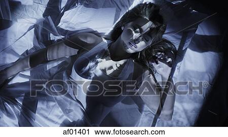 Stock Image - Image projection on sleeping woman laying in bed. Fotosearch