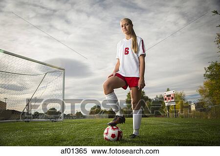 Low angle portrait of athlete standing with soccer ball on field under cloudy sky View Large Photo Image Stock Photography - Low angle portrait of athlete standing with soccer ball on field under cloudy sky. Fotosearch