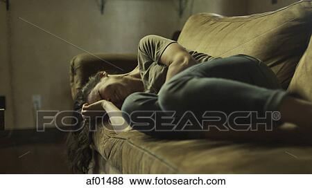 Low angle selective focus view of upset woman crying on dingy sofa View Large Photo Image Stock Photo - Low angle selective focus view of upset woman crying on dingy sofa. Fotosearch