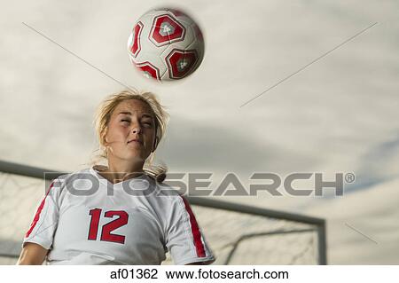 Low angle view of athlete hitting ball with head in soccer goal under cloudy sky View Large Photo Image Stock Image - Low angle view of athlete hitting ball with head in soccer goal under cloudy sky. Fotosearch