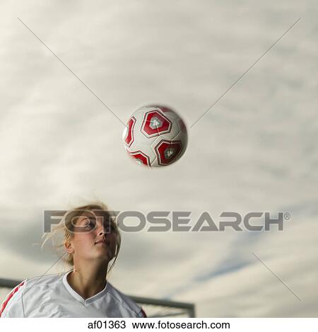 Low angle view of athlete hitting ball with head in soccer goal under cloudy sky View Large Photo Image Stock Image - Low angle view of athlete hitting ball with head in soccer goal under cloudy sky. Fotosearch