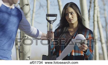 Low angle view of boyfriend comforting upset girlfriend with toilet paper and shovel in remote woods View Large Photo Image Picture - Low angle view of boyfriend comforting upset girlfriend with toilet paper and shovel in remote woods. Fotosearch