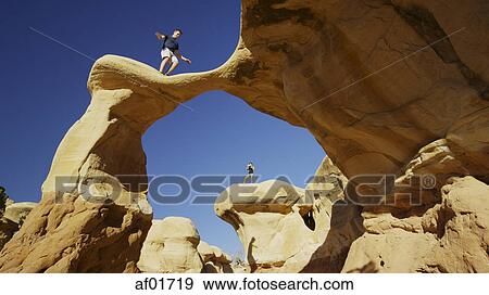 Low angle view of climbers balancing on scenic rock formations under clear blue sky View Large Photo Image Stock Photo - Low angle view of climbers balancing on scenic rock formations under clear blue sky. Fotosearch