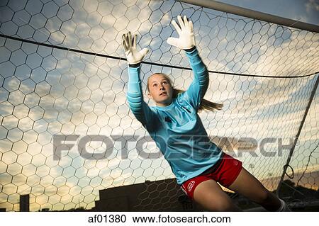 Low angle view of goalie jumping and reaching for soccer ball in goal under blue sky View Large Photo Image Stock Image - Low angle view of goalie jumping and reaching for soccer ball in goal under blue sky. Fotosearch