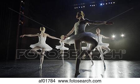 Low angle view of serious ballet dancers in costume performing onstage in show View Large Photo Image Picture - Low angle view of serious ballet dancers in costume performing onstage in show. Fotosearch