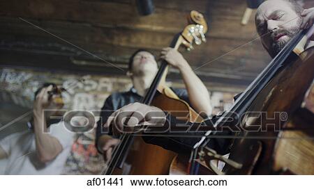 Low angle view of serious musicians playing violin in band in cafe View Large Photo Image Stock Image - Low angle view of serious musicians playing violin in band in cafe. Fotosearch