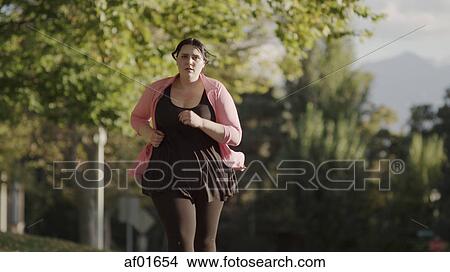 Picture - Low angle view of serious runner jogging outdoors. Fotosearch