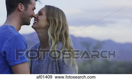 Low angle view of smiling couple touching noses in remote landscape View Large Photo Image Stock Photo - Low angle view of smiling couple touching noses in remote landscape. Fotosearch