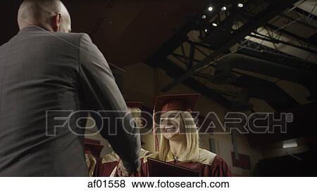 Low angle view of teacher shaking student's hand during graduation ceremony View Large Photo Image Stock Photo - Low angle view of teacher shaking student's hand during graduation ceremony. Fotosearch