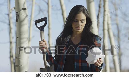 Low angle view of upset woman holding toilet paper and shovel in remote woods View Large Photo Image Stock Image - Low angle view of upset woman holding toilet paper and shovel in remote woods. Fotosearch