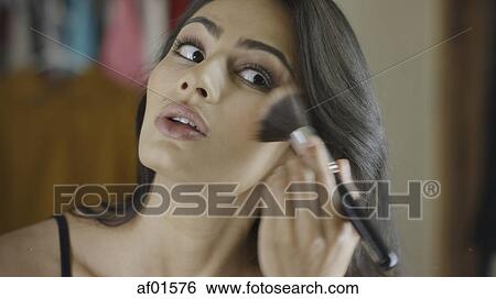 Low angle view of woman applying blush makeup in mirror View Large Photo Image Stock Photograph - Low angle view of woman applying blush makeup in mirror. Fotosearch