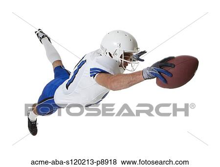 Stock Photo - Male player of American football catching ball, studio shot. Fotosearch
