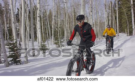 Men riding mountain bikes in remote snowy forest View Large Photo Image Stock Image - Men riding mountain bikes in remote snowy forest. Fotosearch