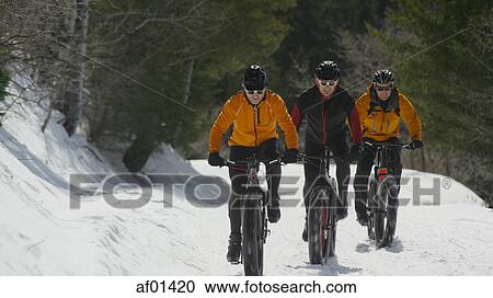 Men riding mountain bikes on remote snowy hillside View Large Photo Image Stock Image - Men riding mountain bikes on remote snowy hillside. Fotosearch