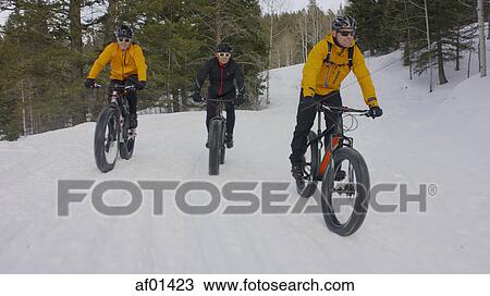 Men riding mountain bikes on remote snowy hillside View Large Photo Image Stock Image - Men riding mountain bikes on remote snowy hillside. Fotosearch