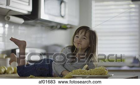 Naughty messy girl laying on kitchen counter eating plate of spaghetti View Large Photo Image Stock Image - Naughty messy girl laying on kitchen counter eating plate of spaghetti. Fotosearch
