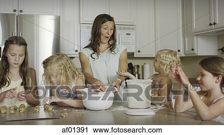 Playful mother and daughters baking cookies together in kitchen View Large Photo Image Stock Image - Playful mother and daughters baking cookies together in kitchen. Fotosearch