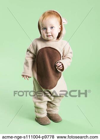 Stock Photo - Portrait of baby girl (12-17 months) in bear costume for Halloween. Fotosearch
