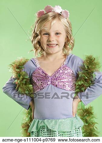 Stock Photo - Portrait of girl (6-7) in Mermaid costume for Halloween. Fotosearch