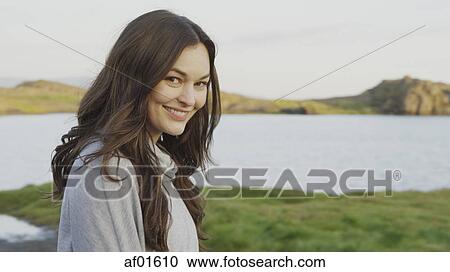 Portrait of smiling in field near lake in remote landscape under blue sky View Large Photo Image Stock Image - Portrait of smiling in field near lake in remote landscape under blue sky. Fotosearch