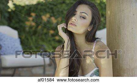 Picture - Portrait of sultry woman with long hair wearing swimsuit. Fotosearch
