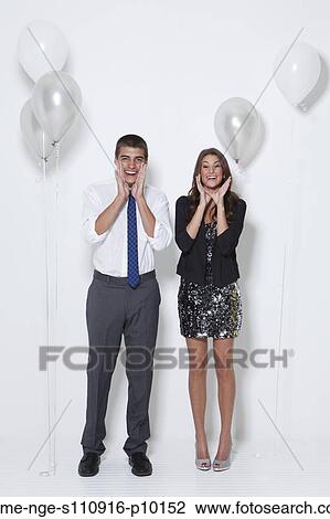 Stock Image - Portrait of surprised young couple at party. Fotosearch
