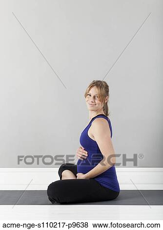 Stock Photo - Portrait of young of pregnant woman, studio shot. Fotosearch