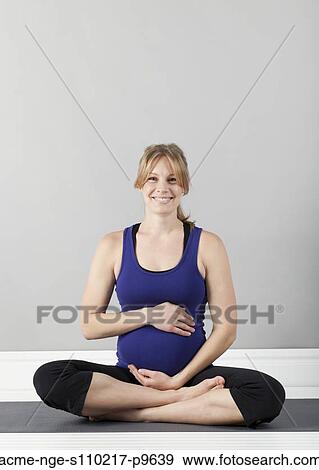 Stock Photo - Portrait of young of pregnant woman, studio shot. Fotosearch