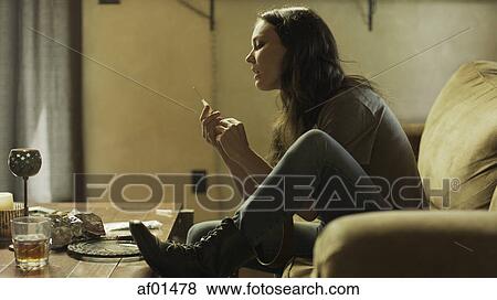 Profile of drug addict loading syringe needle for injection on dingy sofa View Large Photo Image Stock Photo - Profile of drug addict loading syringe needle for injection on dingy sofa. Fotosearch