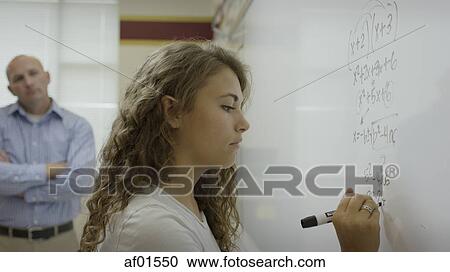 Profile view of student writing math equation on white board in classroom View Large Photo Image Stock Image - Profile view of student writing math equation on white board in classroom. Fotosearch