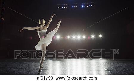 Stock Image - Rear view of serious ballet dancer in costume performing onstage in show. Fotosearch