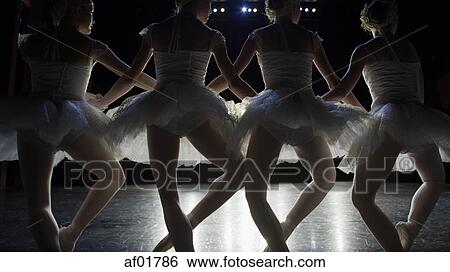 Rear view of silhouette of serious ballet dancers in costume performing onstage in show View Large Photo Image Stock Photograph - Rear view of silhouette of serious ballet dancers in costume performing onstage in show. Fotosearch