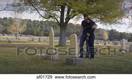 Sad boyfriend and girlfriend hugging at grave in lonely cemetery View Large Photo Image Stock Photo - Sad boyfriend and girlfriend hugging at grave in lonely cemetery. Fotosearch