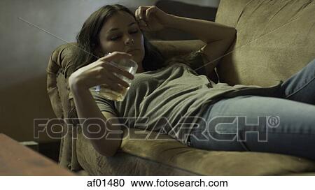 Sad woman drinking alcoholic drink on dingy sofa View Large Photo Image Stock Image - Sad woman drinking alcoholic drink on dingy sofa. Fotosearch