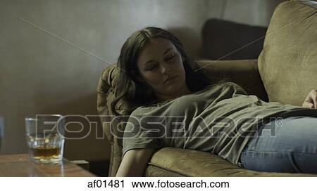 Sad woman sleeping near alcoholic drink on dingy sofa View Large Photo Image Stock Image - Sad woman sleeping near alcoholic drink on dingy sofa. Fotosearch
