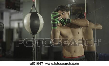 Selective focus view of boxer working out and training with punching ball in gym View Large Photo Image Stock Photo - Selective focus view of boxer working out and training with punching ball in gym. Fotosearch