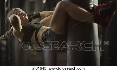 Selective focus view of female boxer working out and doing sit-ups on punching bag in gym View Large Photo Image Stock Photography - Selective focus view of female boxer working out and doing sit-ups on punching bag in gym. Fotosearch
