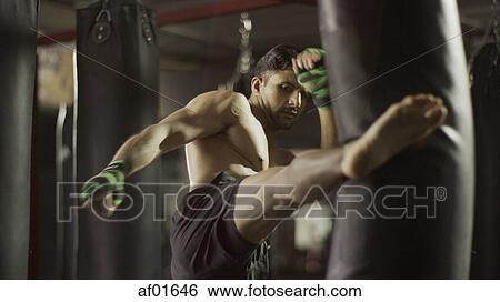 Selective focus view of man kickboxing punching bag in gym View Large Photo Image Stock Photograph - Selective focus view of man kickboxing punching bag in gym. Fotosearch