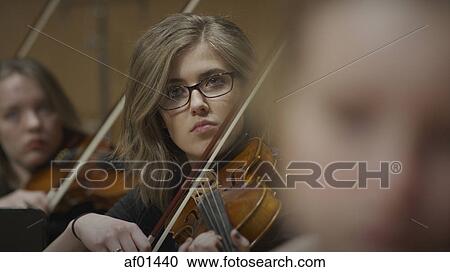 Selective focus view of serious teenage girl musician playing violin in band class View Large Photo Image Stock Image - Selective focus view of serious teenage girl musician playing violin in band class. Fotosearch