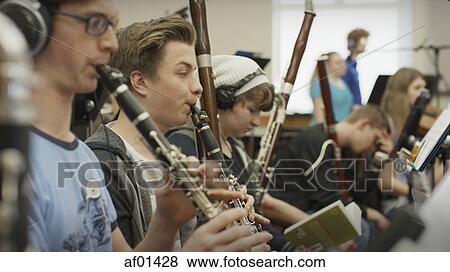 Selective focus view of serious teenage boy musician playing clarinet in band class View Large Photo Image Stock Photo - Selective focus view of serious teenage boy musician playing clarinet in band class. Fotosearch