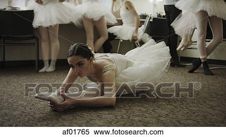 Stock Photography - Serious ballet dancer in costume stretching backstage before show. Fotosearch