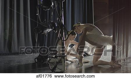 Serious ballet dancers in costume tying ballet slippers backstage during show View Large Photo Image Stock Photograph - Serious ballet dancers in costume tying ballet slippers backstage during show. Fotosearch