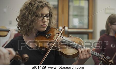 Serious teenage girl musician playing violin in band class View Large Photo Image Stock Photo - Serious teenage girl musician playing violin in band class. Fotosearch