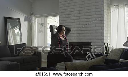 Serious woman working out in modern living room View Large Photo Image Stock Image - Serious woman working out in modern living room. Fotosearch