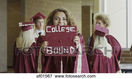 Smiling student posing with decorated mortarboards at graduation View Large Photo Image Stock Photo - Smiling student posing with decorated mortarboards at graduation. Fotosearch
