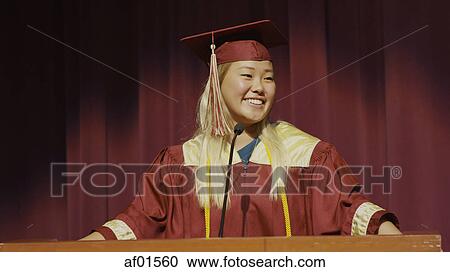 Smiling student speaking at podium on stage during graduation ceremony View Large Photo Image Stock Image - Smiling student speaking at podium on stage during graduation ceremony. Fotosearch