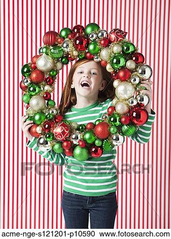 Studio portrait of girl (4-5) holding Christmas decoration View Large Photo Image Stock Image - Studio portrait of girl (4-5) holding Christmas decoration. Fotosearch